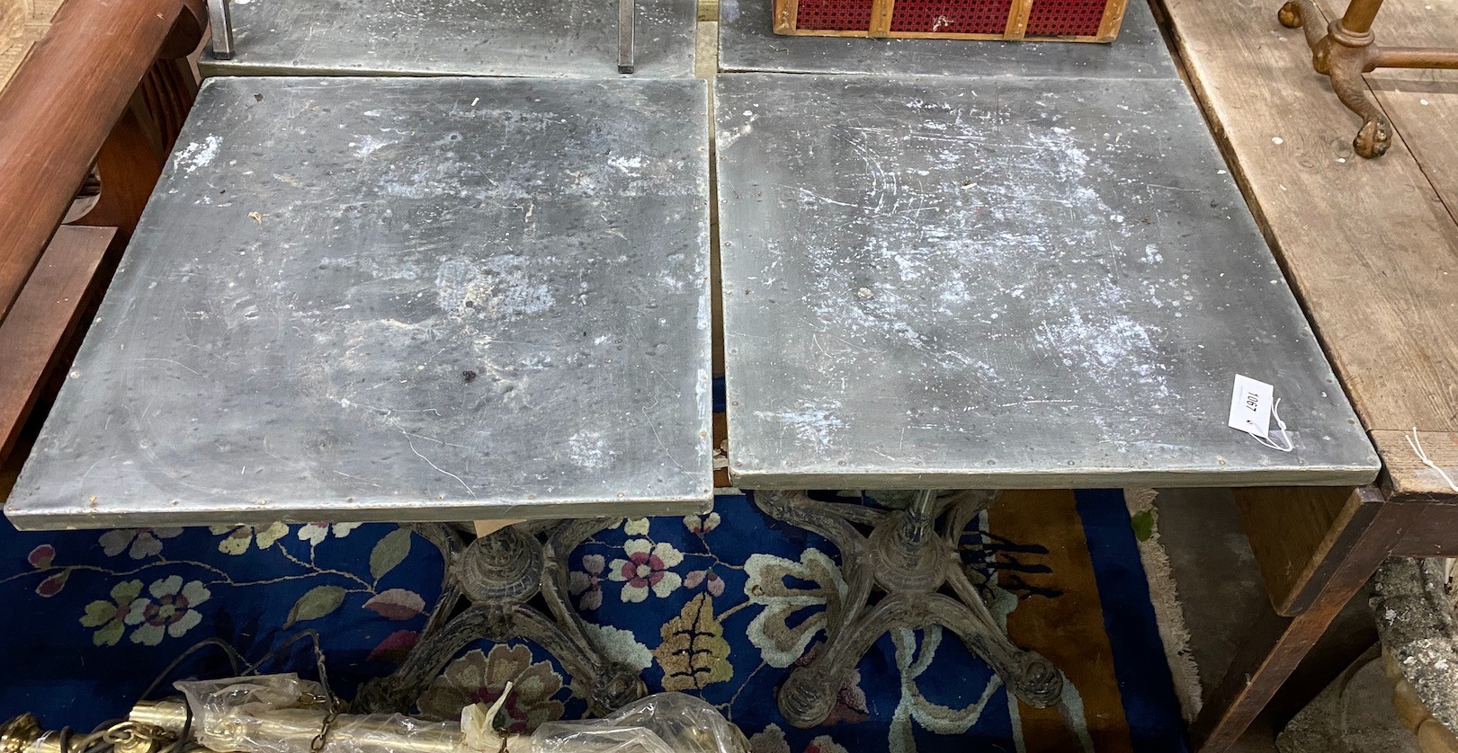 A pair of zinc topped cafe tables with cast iron bases, width 60cm depth 60cm height 74cm